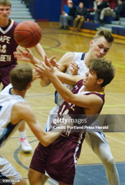 Cape Elizabeth David Hare grapples for a loose ball with York Chris Cummins and Tim MacDonald in the second half at York boys basketball.