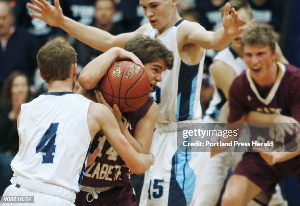 Cape Elizabeth David Hare drives through York defense Chris Cummins and Will MacDonald in second half action at York boys basketball.