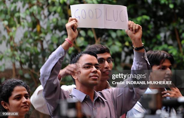 Fans wish good luck as cricket captain Mahendra Singh Dhoni speaks at a pre-departure press conference in Mumbai on September 17, 2009. The Indian...