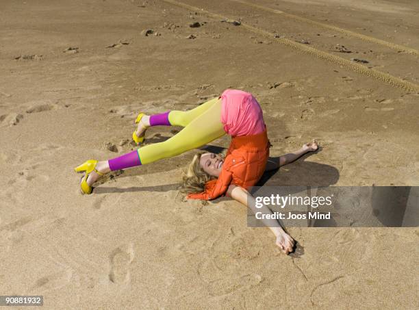 woman practising yoga exercise on beach, laughing - inarcare la schiena foto e immagini stock