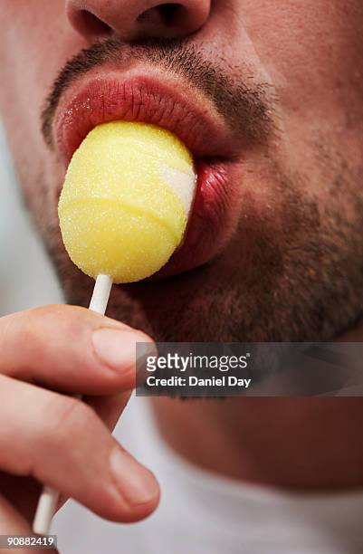 man sucking a lollipop  - lecca lecca foto e immagini stock