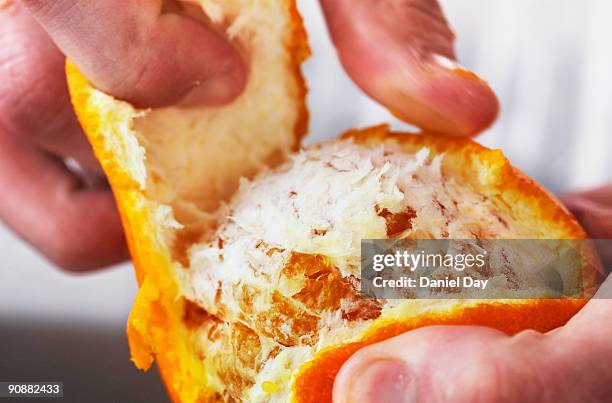 man pealing fruit - mondo fotografías e imágenes de stock