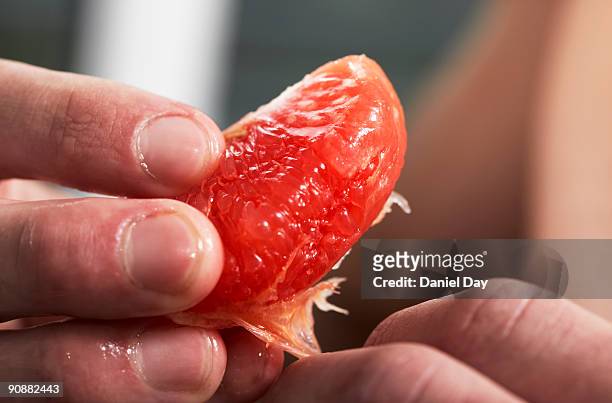 man eating fruit - grapefruit stock pictures, royalty-free photos & images