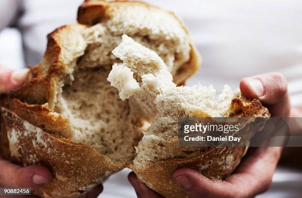 man breaking bread  - white bread stockfoto's en -beelden