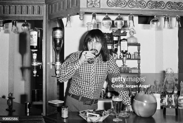 John Entwistle of The Who taking a drink at the bar in his house in 1972 in England.