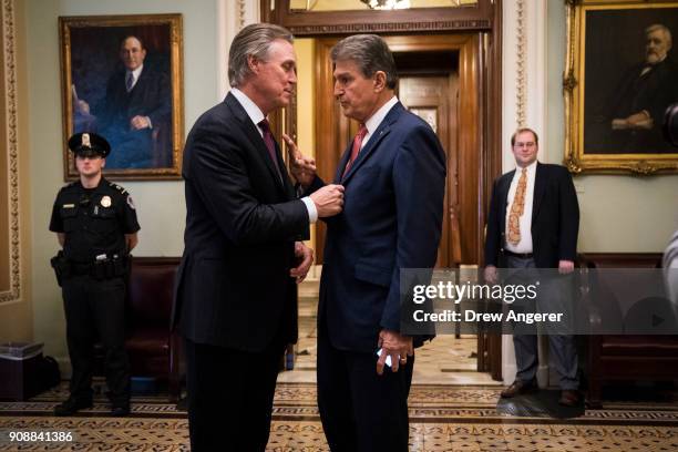 Sen. David Perdue talks with Sen. Joe Manchin after the Senate passed a procedural vote for a continuing resolution to fund the federal government,...