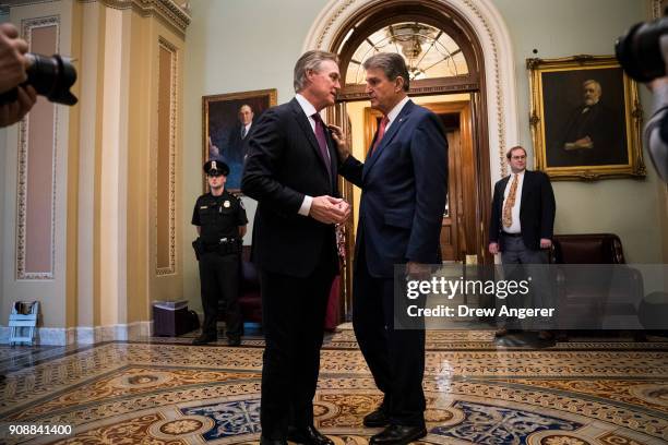 Sen. David Perdue talks with Sen. Joe Manchin after the Senate passed a procedural vote for a continuing resolution to fund the federal government,...