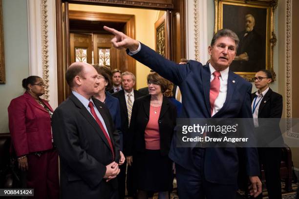 Chris Coons and Sen. Joe Manchin emerge from the Senate floor after the Senate passed a procedural vote for a continuing resolution to fund the...