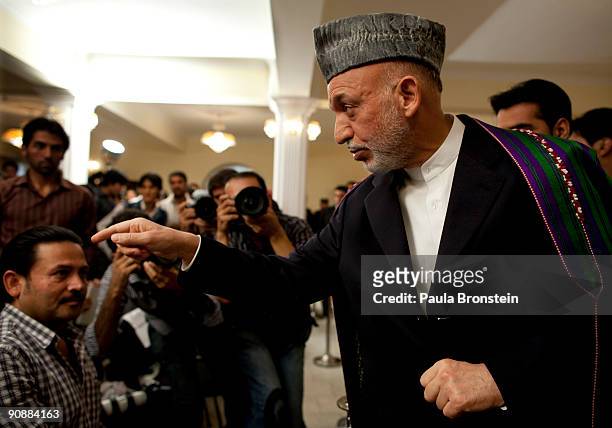 President Hamid Karzai points as he speaks to the media for the first time since full preliminary results were announced at the Presidential palace...