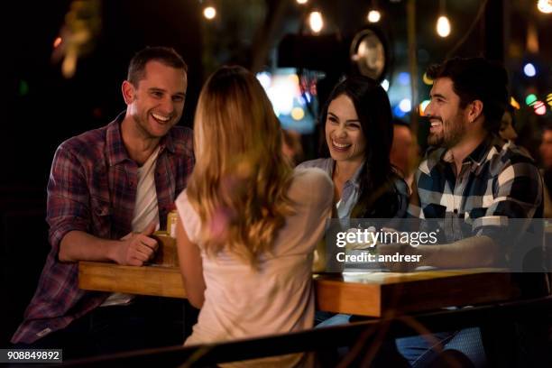 feliz grupo de amigos comiendo en un restaurante - amigos bar fotografías e imágenes de stock