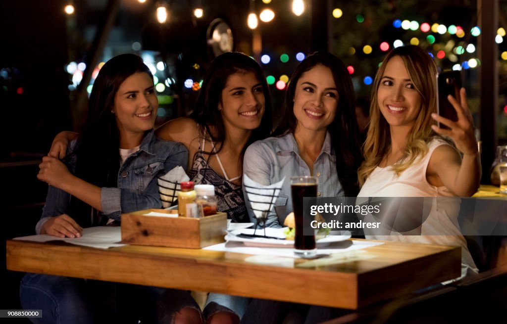 Group of female friends taking a selfie at a restaurant