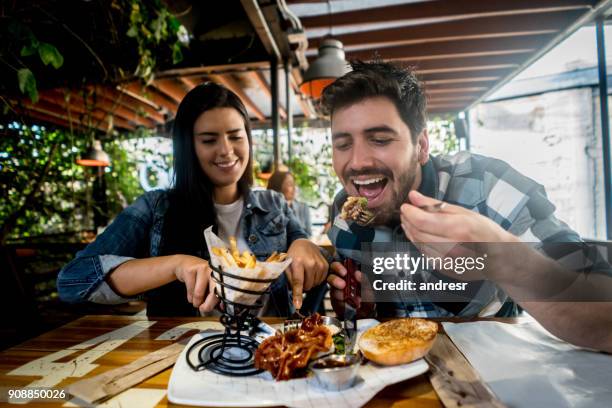 amar par comer juntos en el restaurante de burger - amigos hombres en restaurant fotografías e imágenes de stock