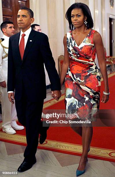 President Barack Obama and first lady Michelle Obama hold hands as they arrive for the Medal of Honor ceremony for U.S. Army Sergeant First Class...