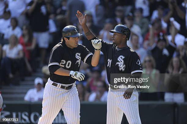 Carlos Quentin high fives DeWayne Wise of the Chicago White Sox after Quentin hit a two run home run against the Boston Red Sox on September 7, 2009...