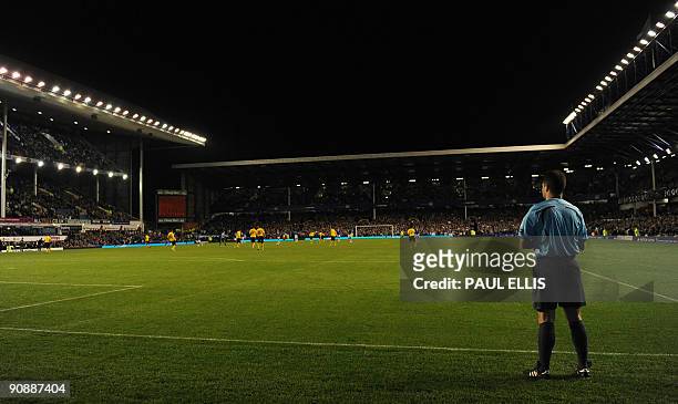The fifth official stands behind the goal line before Everton and AEK Athens play their UEFA Europa League football match at Goodison Park in...