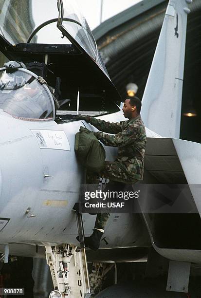 Staff Sgt. Jeffrey R. Seeley, a crew chief with the 53rd Fighter Squadron, holds a helmet bag as the pilot of an F-15C Eagle aircraft settles into...