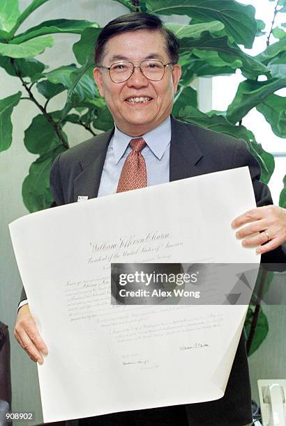 Professor Chang-Lin Tien holds his appointment certificate which signed by President Clinton after he was sworn in as a National Science Board member...