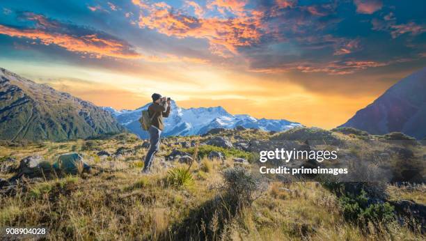 giovane viaggiatore che scatta foto nella destinazione mt cook famaus in nuova zelanda - queenstown new zealand foto e immagini stock