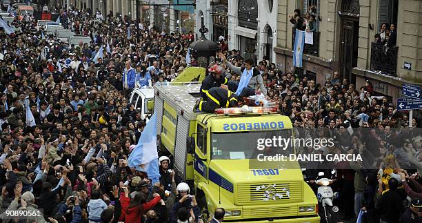 The newly-crowned US Open champion Juan Martin Del Potro waves at people gathered to see him from a fire engine on September 17 following his arrival...