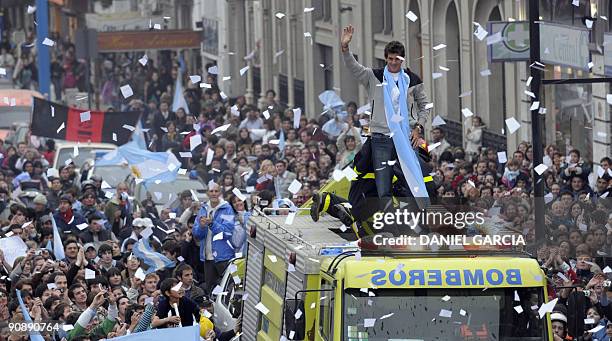 The newly-crowned US Open champion Juan Martin Del Potro waves at people gathered to see him from a fire engine on September 17 following his arrival...