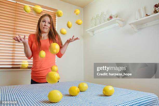 a woman throws up her hands after being dealt a lot of lemons. - harpazo hope stock pictures, royalty-free photos & images