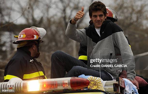 The newly-crowned US Open champion Juan Martin Del Potro gives his thumb up at people gathered to see him from a fire engine on September 17...