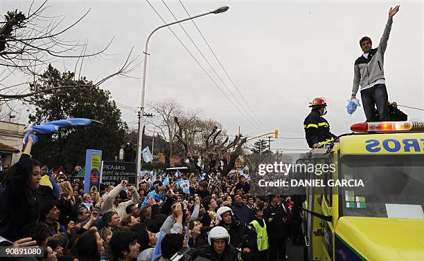 The newly-crowned US Open champion Juan Martin Del Potro waves from a fire engine at people gathered to see him on September 17 following his arrival...