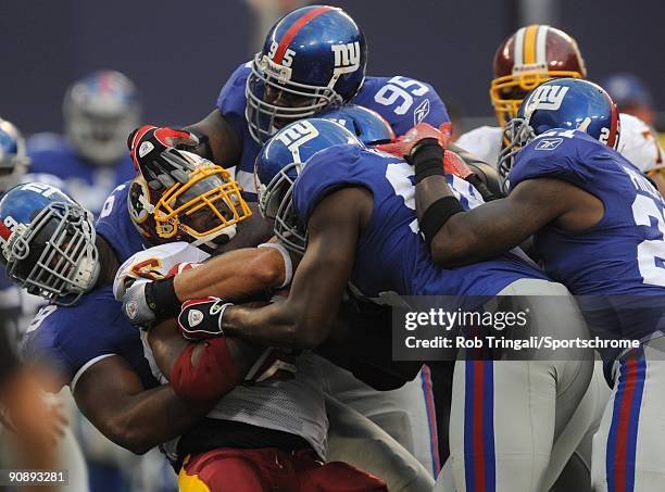 Clinton Portis of the Washington Redskins is tackled by members of the New York Giants defense during their game on September 13, 2009 at Giants...