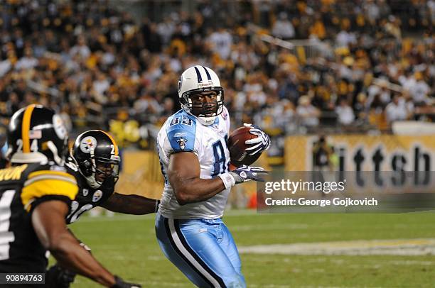 Tight end Alge Crumpler of the Tennessee Titans is pursued by defensive backs Ryan Mundy and Ike Taylor of the Pittsburgh Steelers during a game at...