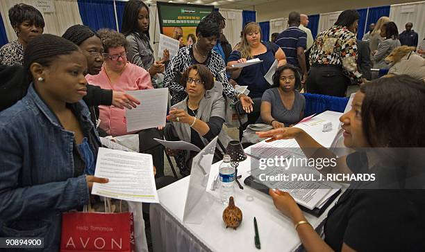 Women seeking employment visit with Bert Greene of "Anointed Words" during an employment guide job fair on September 17, 2009 at the Baltimore...