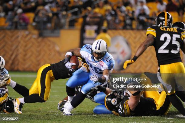 Running back LenDale White of the Tennessee Titans runs against linebacker James Farrior and defensive lineman Brett Keisel of the Pittsburgh...