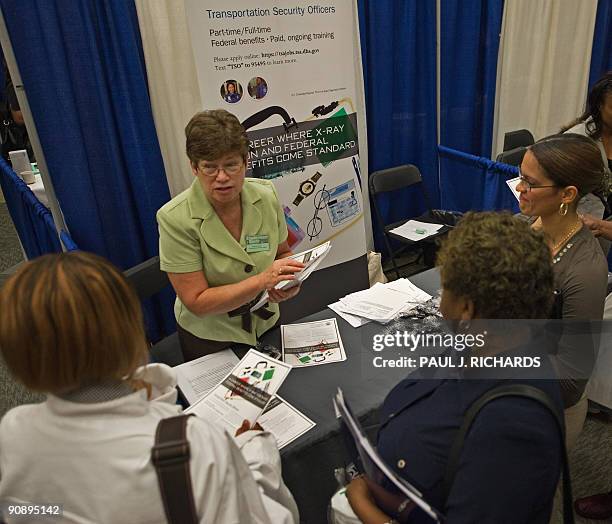 Transportation Security Administration Linda Garwood talks with job seekers about part-time work during an employment guide job fair on September 17,...