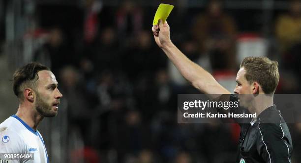 Referee Soeren Storks shows the yellow card to Christopher Handke of Magdeburg during the 3.Liga match between FC Rot Weiss Erfurt and 1.FC Magdeburg...