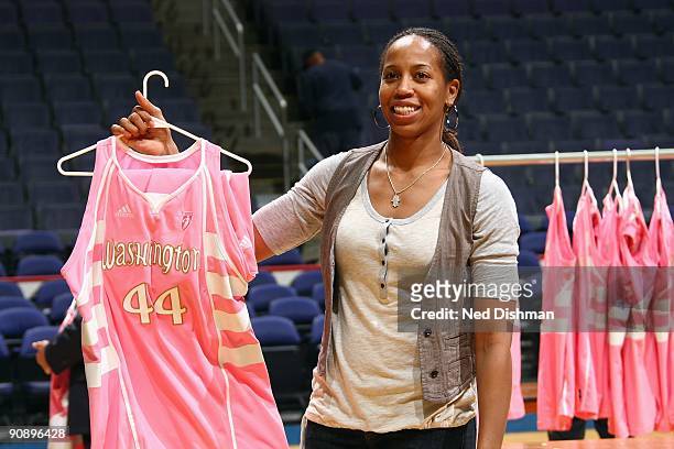 Chasity Melvin of the Washington Mystics auctions off her jersey to raise funds for the WNBA's 'Breast Health Awareness' program following the game...