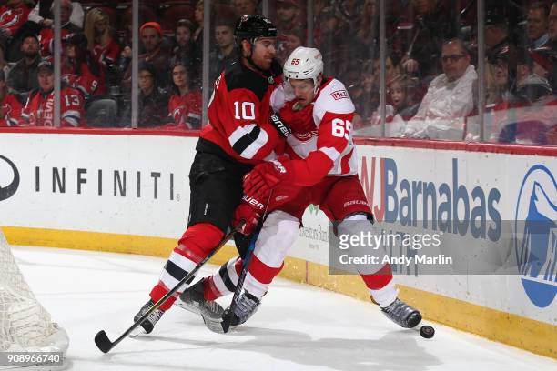 Danny DeKeyser of the Detroit Red Wings battles for the puck against Jimmy Hayes during the game at Prudential Center on January 22, 2018 in Newark,...