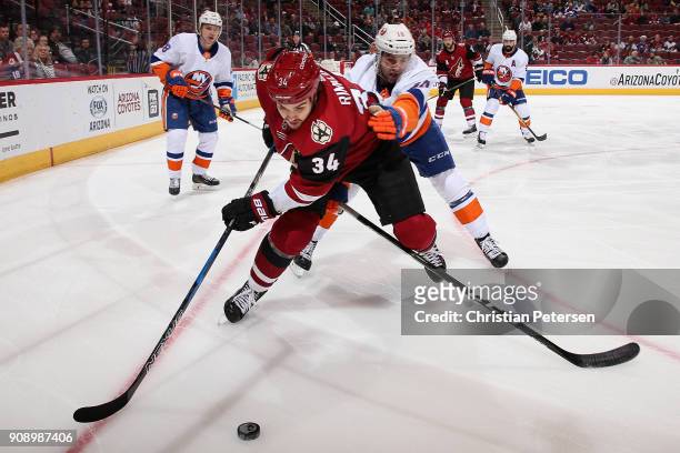 Zac Rinaldo of the Arizona Coyotes skates with the puck ahead of Alan Quine of the New York Islanders during the first period of the NHL game at Gila...