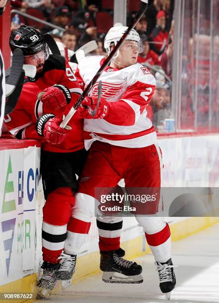 Joe Hicketts of the Detroit Red Wings hits Marcus Johansson of the New Jersey Devils in the third period on January 22, 2018 at Prudential Center in...