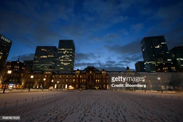 Footprints mark the snow-covered ground in front of the Tokyo Station at dawn in Tokyo, Japan, on Tuesday, Jan. 23, 2018. Japanese electricity prices...