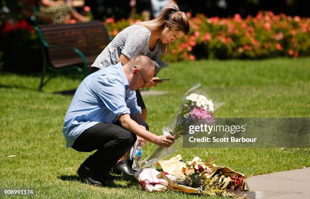 People lay flowers at a plaque to remember those affected by the Bourke Street Mall tragedy at Parliament Gardens Reserve after attending a memorial...