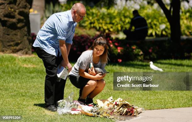 People lay flowers at a plaque to remember those affected by the Bourke Street Mall tragedy at Parliament Gardens Reserve after attending a memorial...