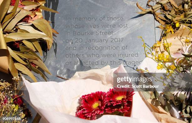 Flowers rest on a plaque to remember those affected by the Bourke Street Mall tragedy at Parliament Gardens Reserve as a memorial is held for victims...