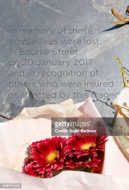 Flowers rest on a plaque to remember those affected by the Bourke Street Mall tragedy at Parliament Gardens Reserve as a memorial is held for victims...