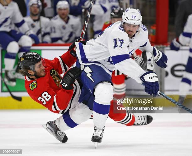 Ryan Hartman of the Chicago Blackhawks falls over the back of Alex Killorn of the Tampa Bay Lightning at the United Center on January 22, 2018 in...