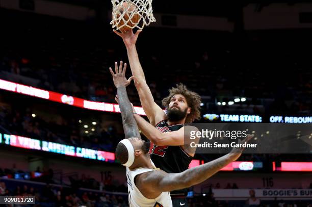 Robin Lopez of the Chicago Bulls shoots over Dante Cunningham of the New Orleans Pelicans during the first half of a NBA game at Smoothie King Center...