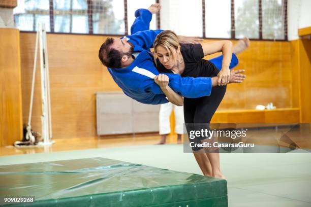 adult woman practicing self defense with judo trainer - self defense stock pictures, royalty-free photos & images