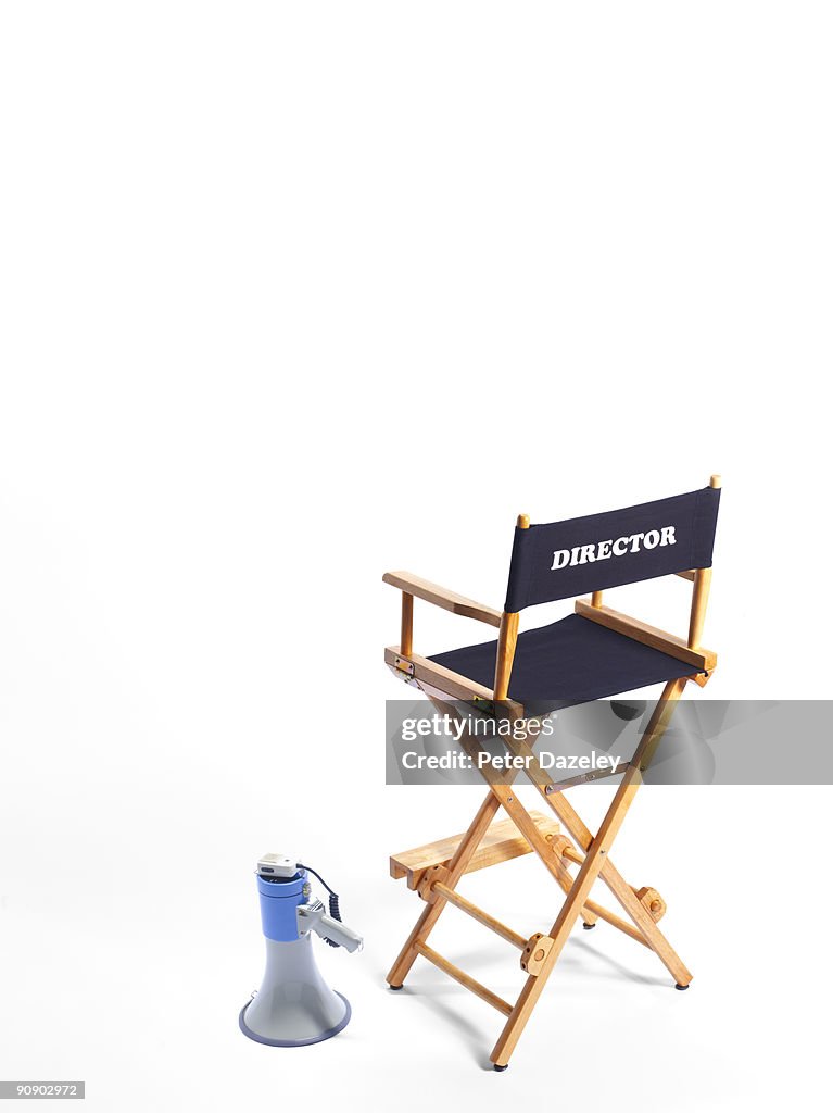 Directors chair and megaphone on white background.