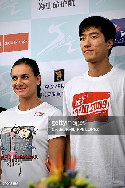 Russian pole vault champion Yelena Isinbayeva stands with Chinese sprint hurdler Liu Xiang during a press conference in Shanghai on September 18,...