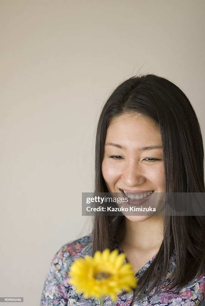 Young woman looking at flower
