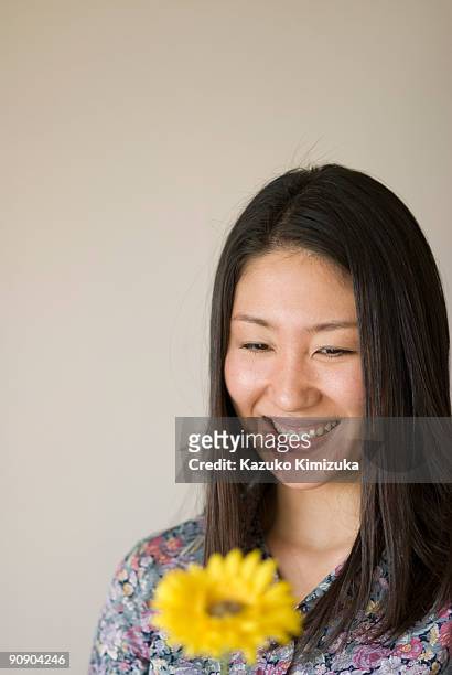 young woman looking at flower - kazuko kimizuka ストックフォトと画像