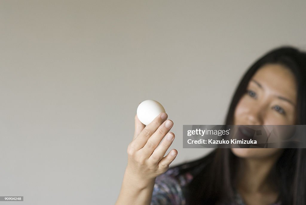 Young woman looking at  an egg